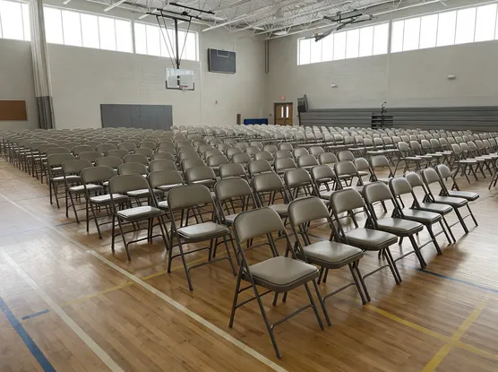 School gymnasium with rows of folding chairs — institutional education segment