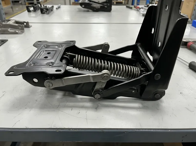 Synchro chair mechanism showing synchronized tilt linkage and spring assembly